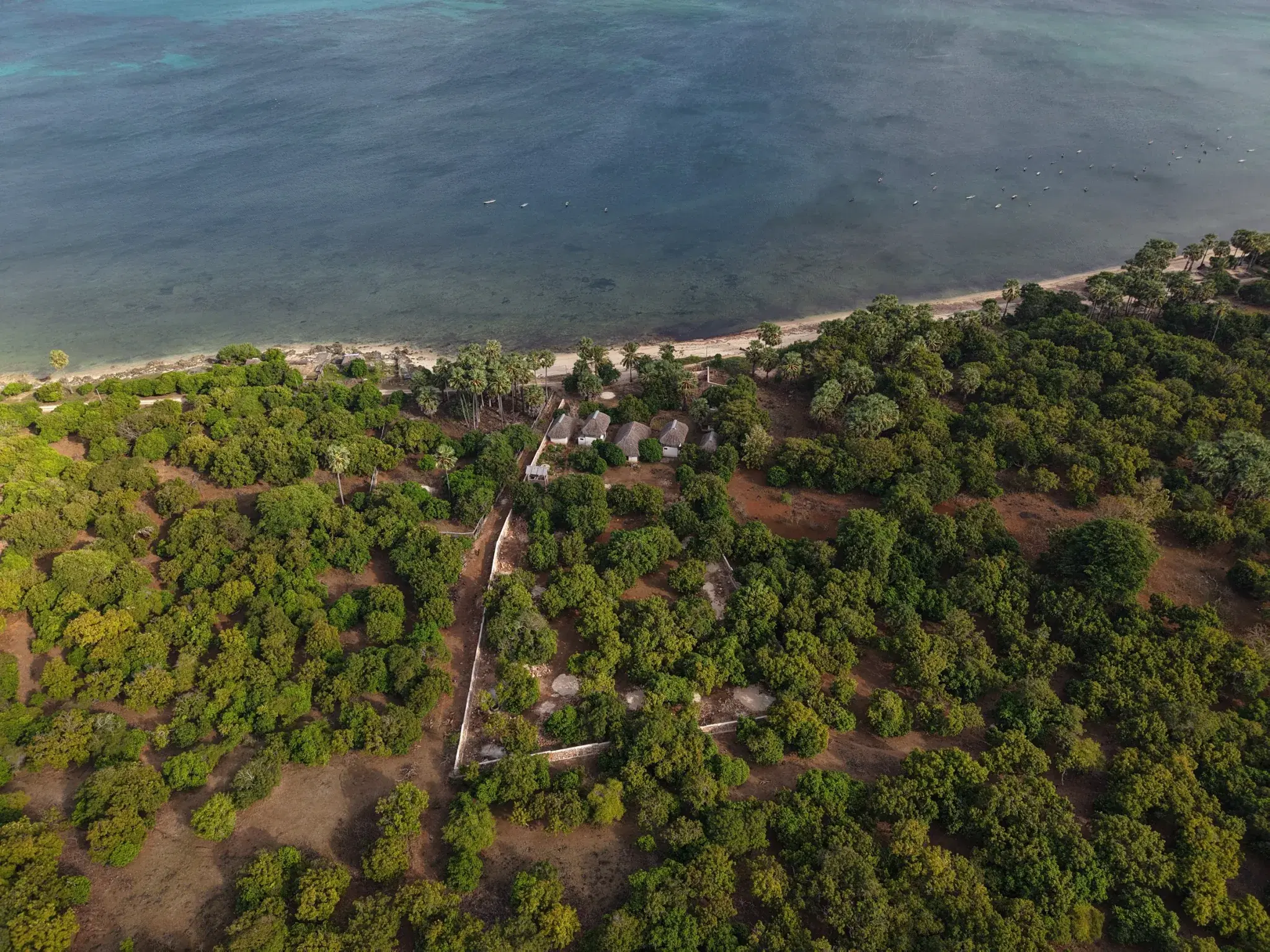 Aerial view of the turquoise reef flat and sandy beach fronting the land