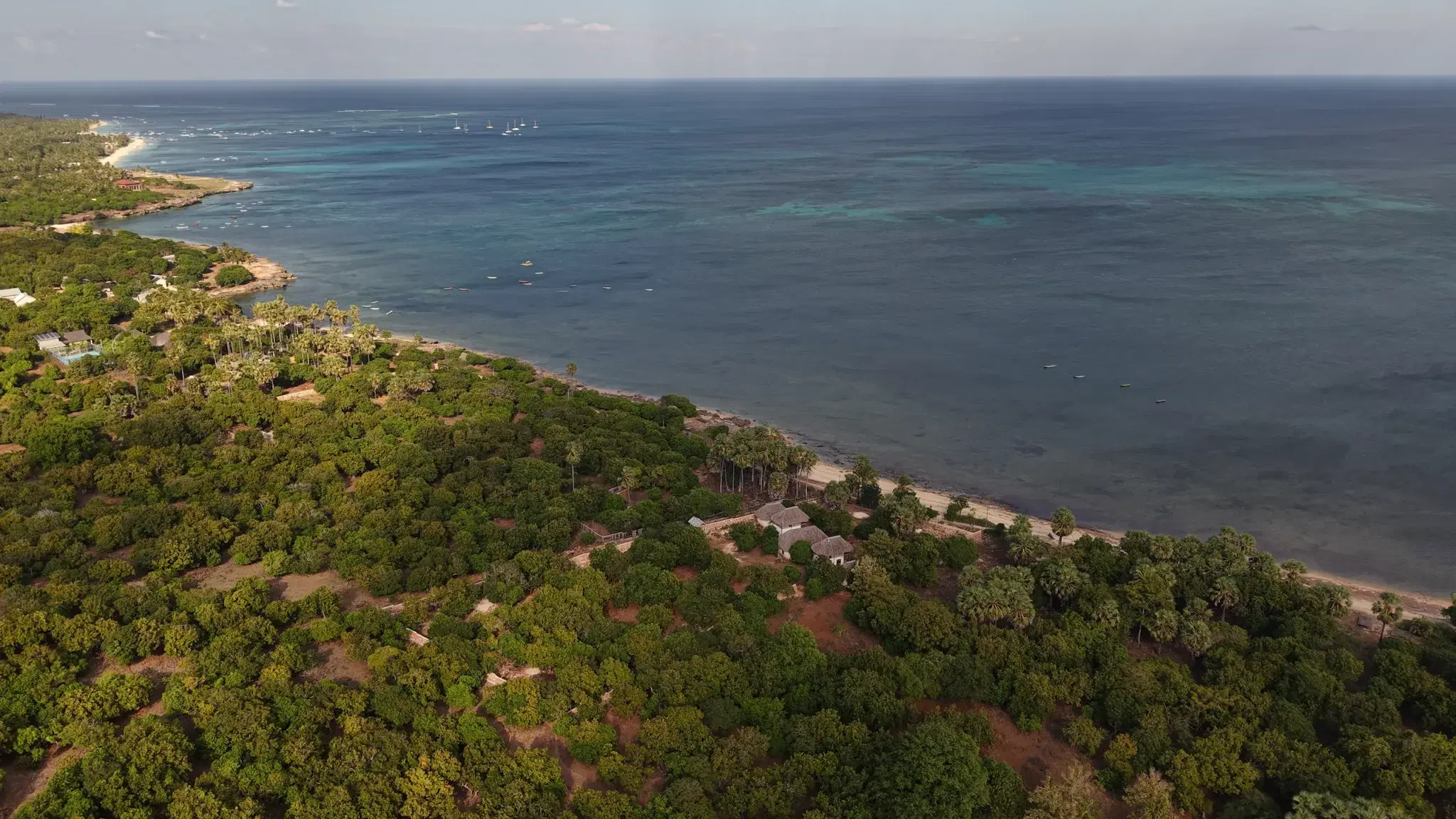 Aerial view north along the Sedeoen coast, the walled parcel in the foreground and sailboats moored off the surf breaks beyond